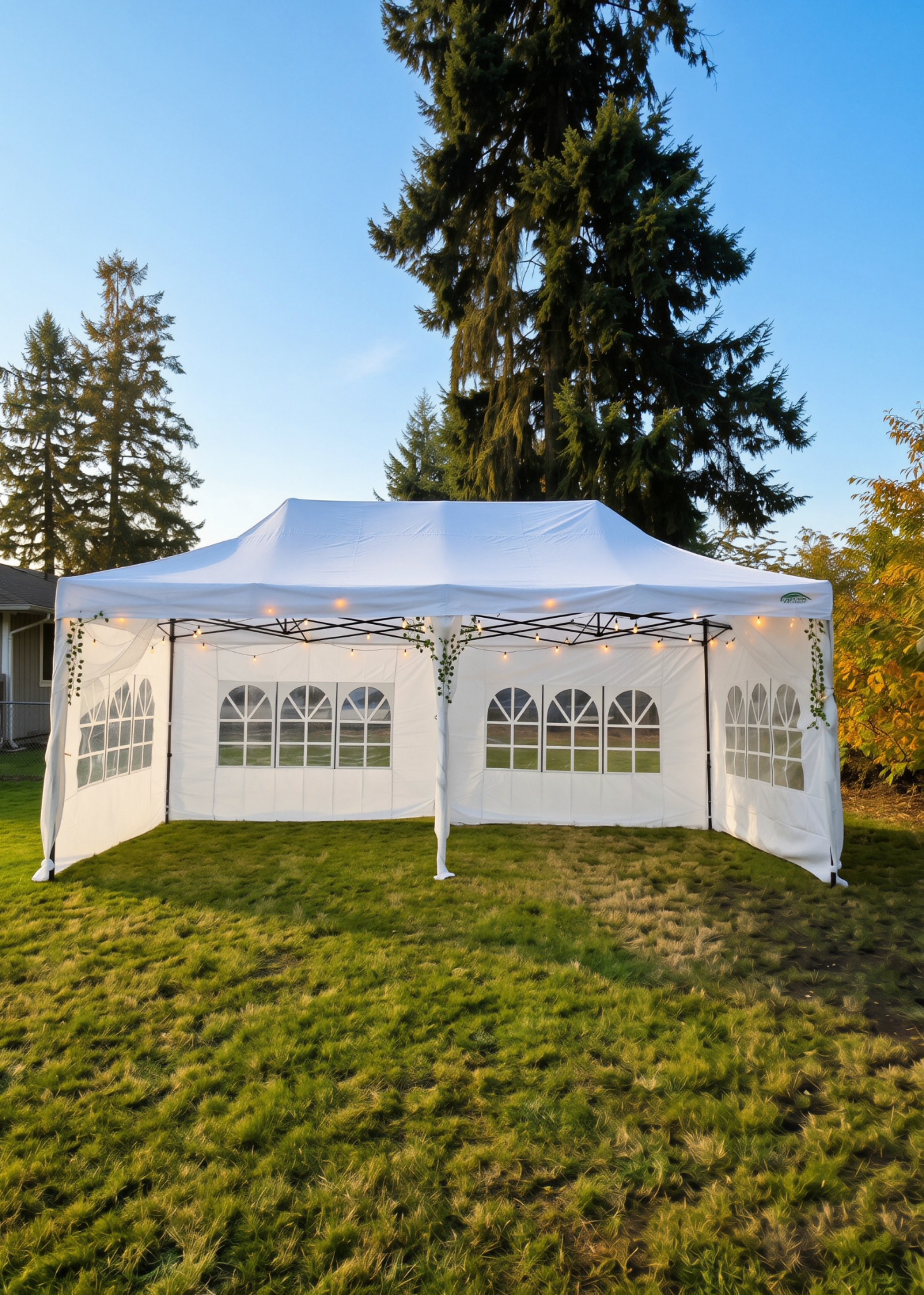White event shade canopy shown with optional window walls, lights, sheer draping and greenery